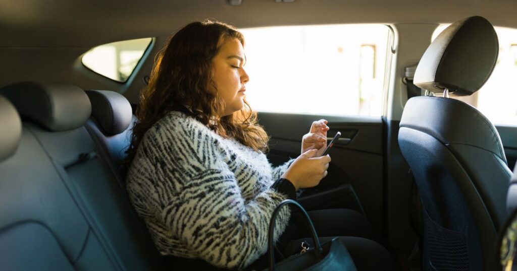 female passenger in the backseat of a rideshare