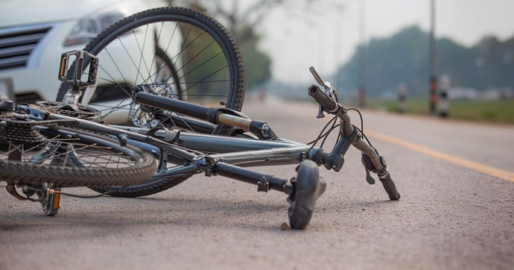 bicycle on the ground after getting hit by a car