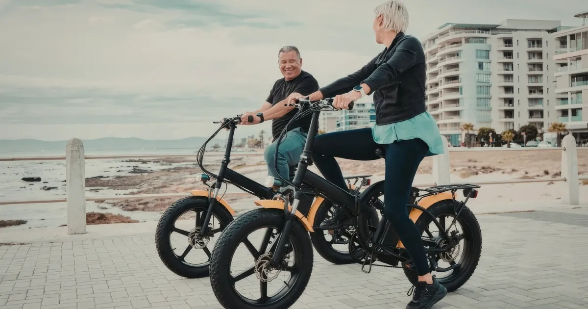 Two people riding e-bikes on the boardwalk unaware of the upcoming New Jersey e-bike law requiring helmets
